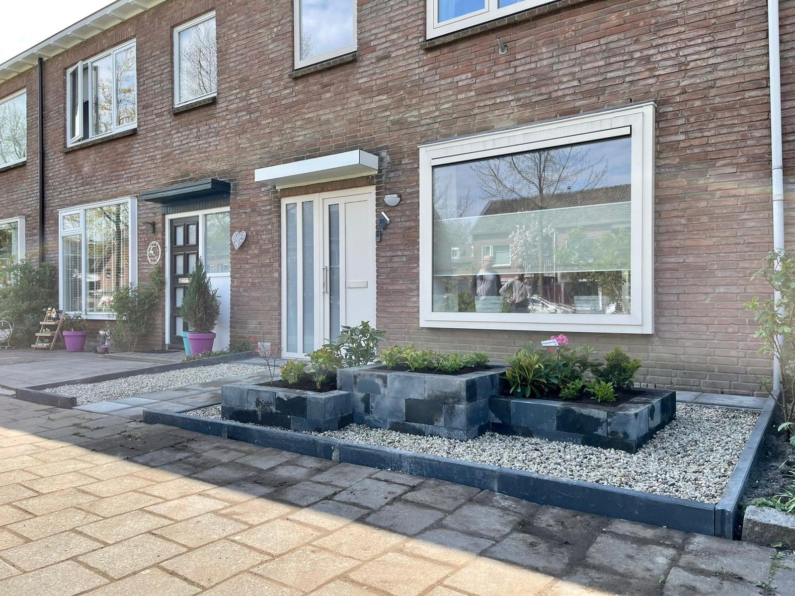 Voortuin met nieuwe bestrating, keerelementen en grindborder